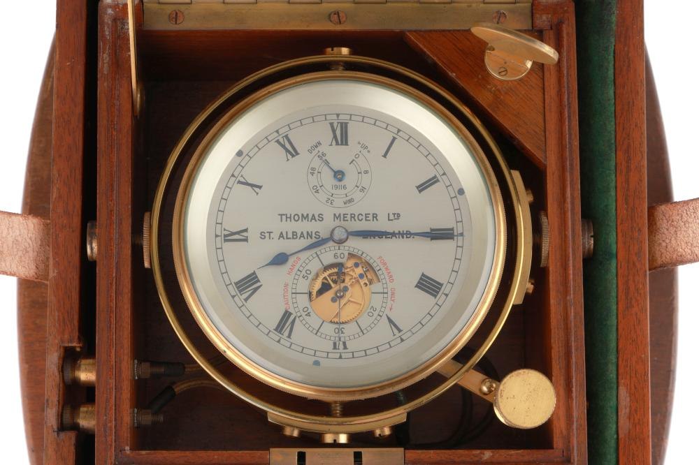 A front-facing view of the Thomas Mercer marine chronometer in its open mahogany deck box, showing the silvered dial, gimbal mounting, and electrical terminals.