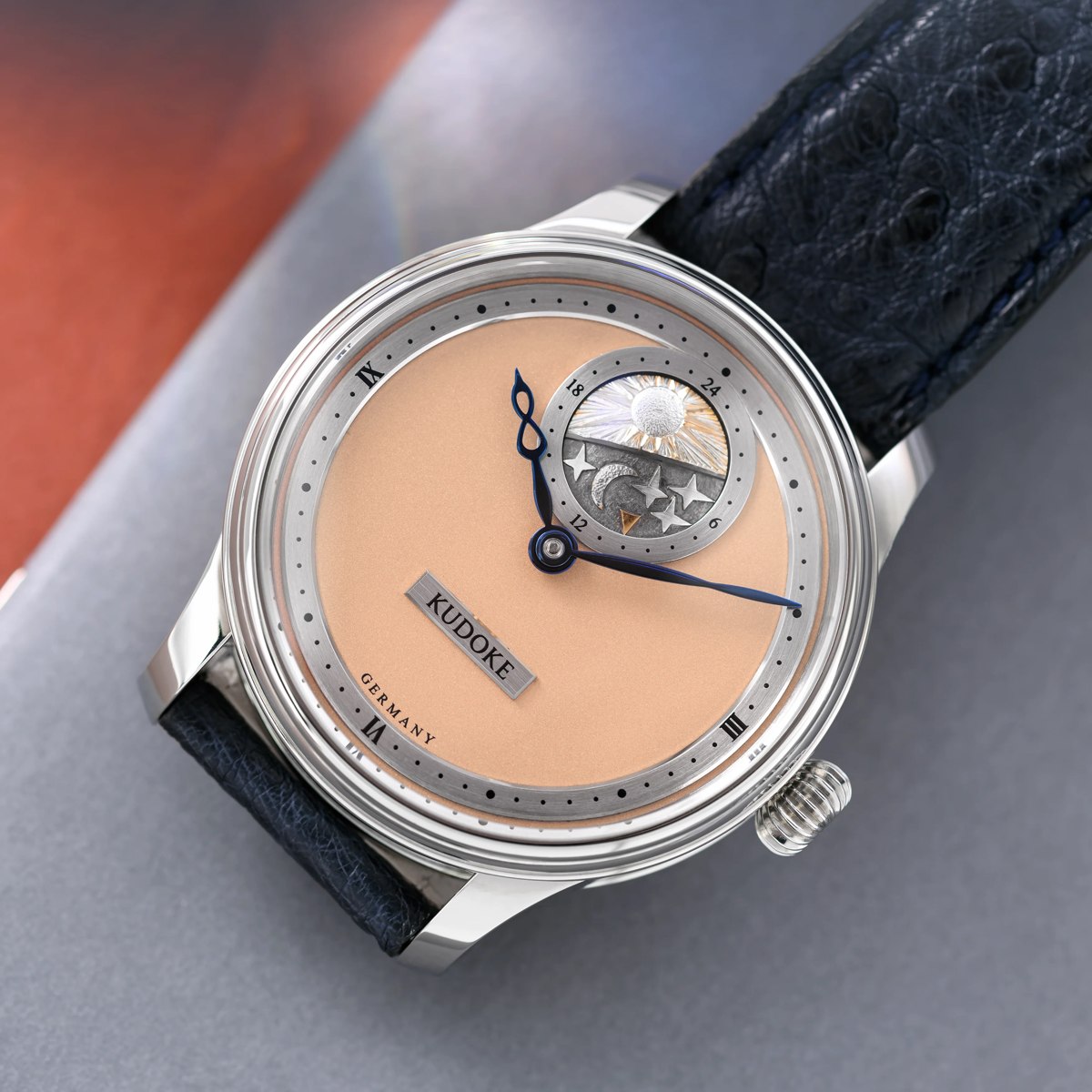 Front view of the Kudoke K2 wristwatch with frosted salmon dial and day/night disc