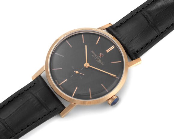 Front three-quarter view of the Revue Thommen wristwatch showing black dial, gold-plated case, and leather strap