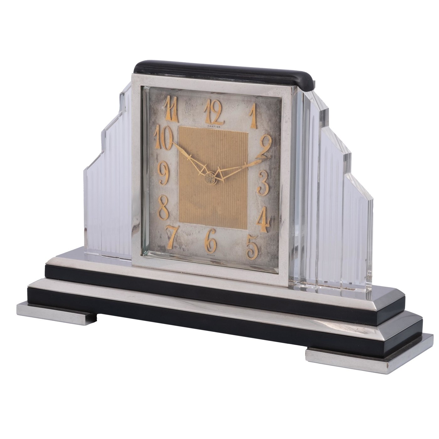 A side-profile view of the Cartier desk clock showing the glass side panels and silver base.