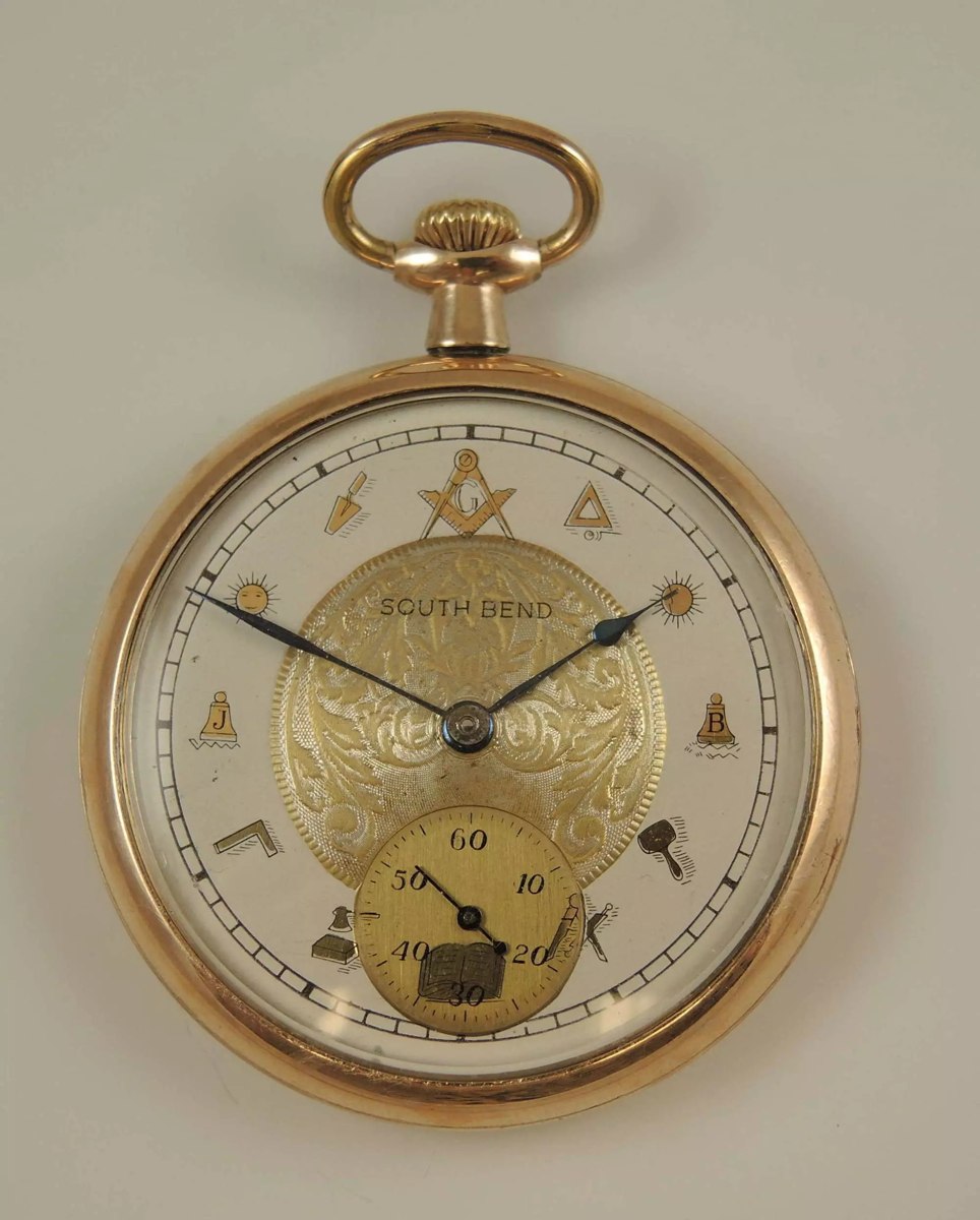 Front view of the South Bend 12-size open-face pocket watch featuring a silvered dial with gilt Masonic emblems