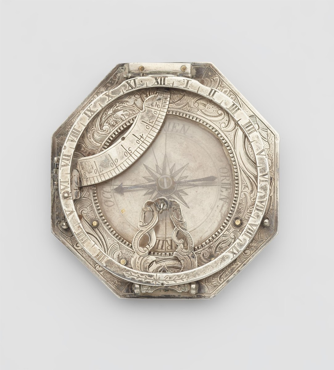 Top view of the octagonal silver equatorial sundial with folded chapter ring, graduated arc, and glazed compass