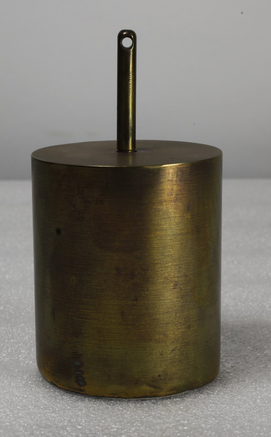Cylindrical clock weight with suspension rod, manufactured by J. Newman, circa 1850s.