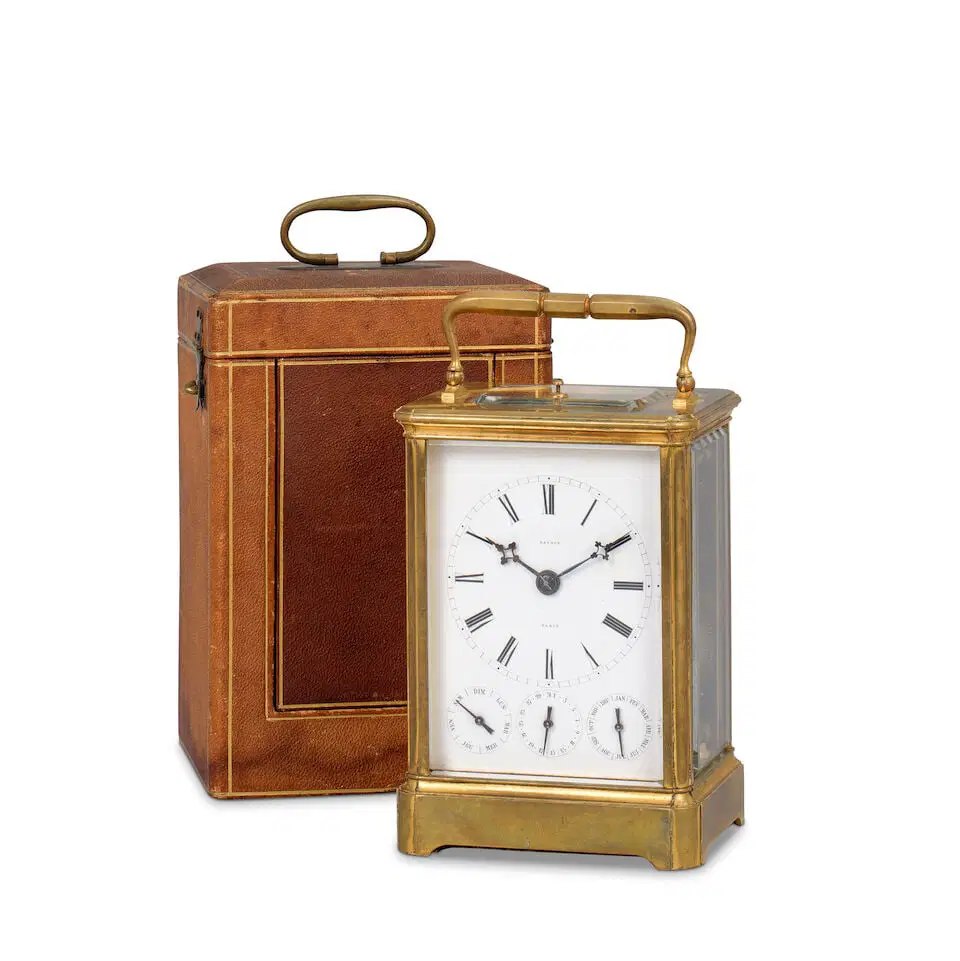 Front three-quarter view of the carriage clock alongside its fitted leather travel case