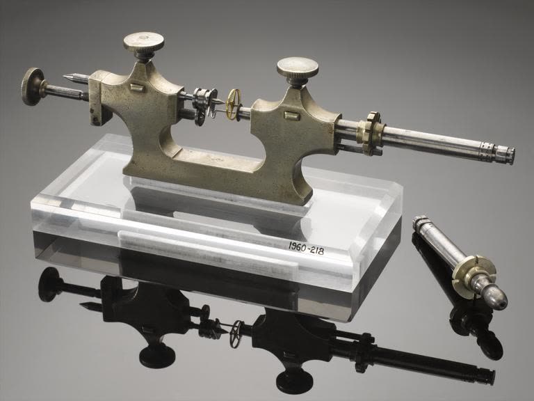 Full view of the jacot tool supported on an acrylic block labelled 1960-218 with an extra runner