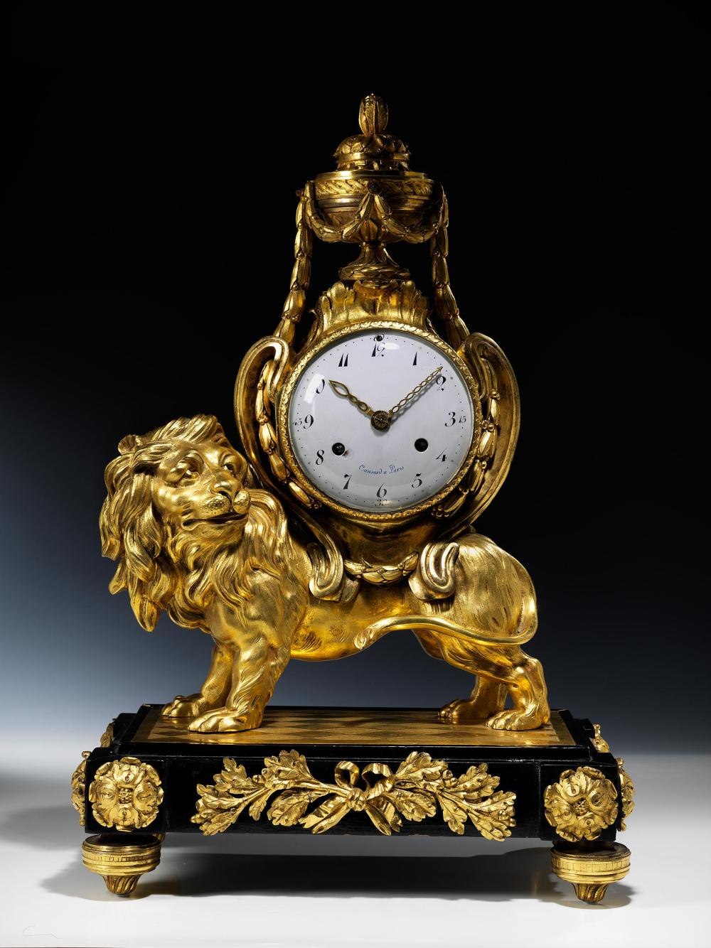Full view of the Louis XVI bronze pendulum clock showing the lion figure base and the vase-shaped clock housing.