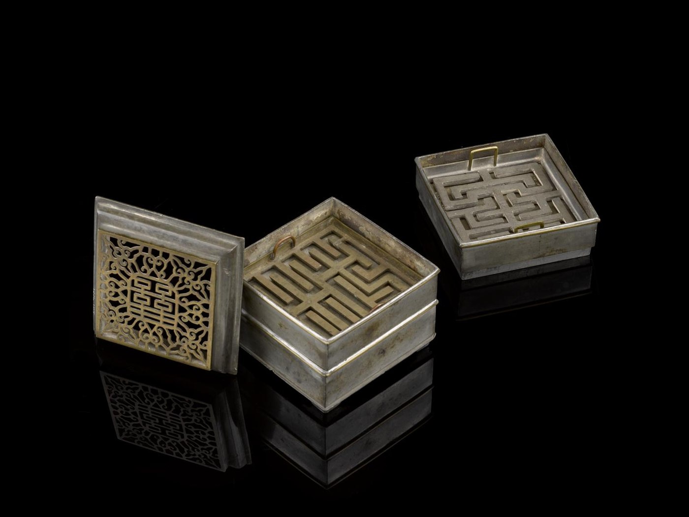 A Chinese incense clock consisting of three trays, two maze stencils, and a latticework lid displaying the 'double happiness' character.