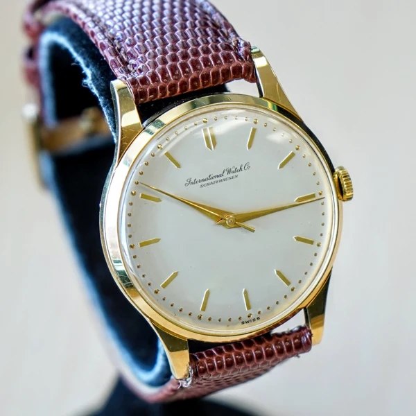 Three-quarter front view of the IWC 18K yellow gold wristwatch on a display mount