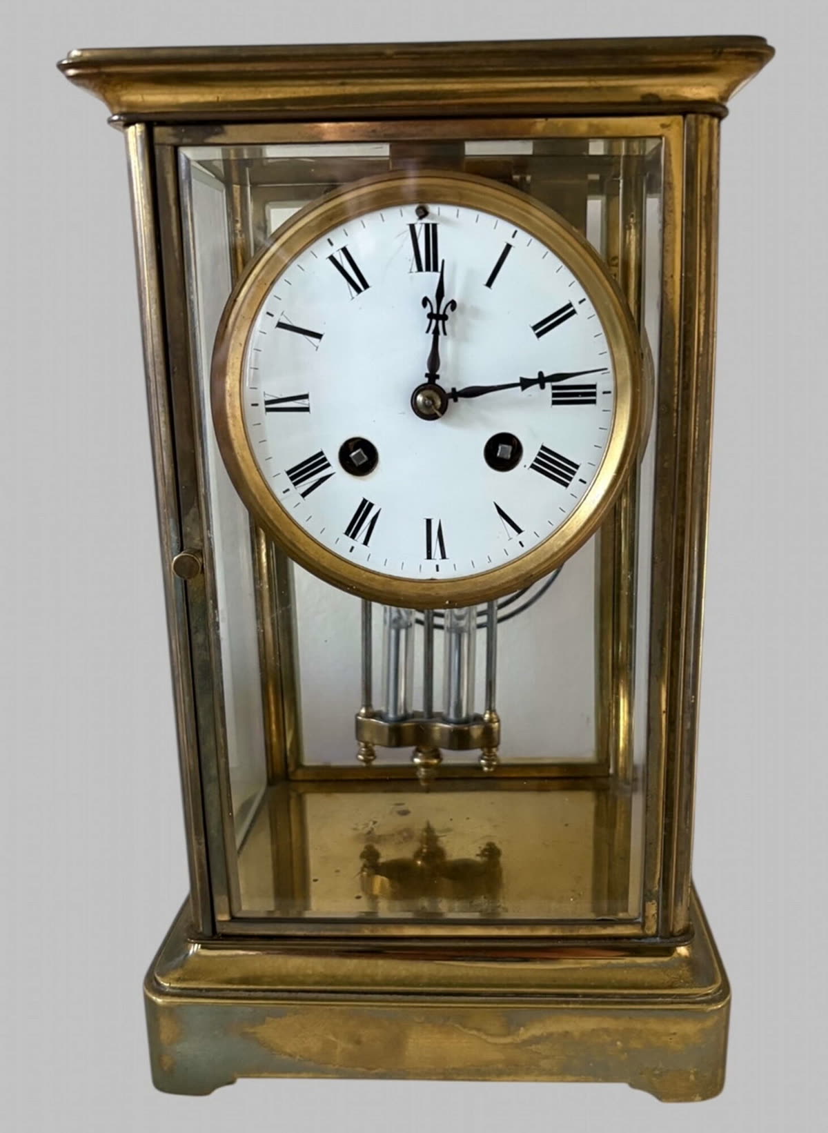 Front view of the brass and bevelled glass crystal regulator clock showing dial and pendulum