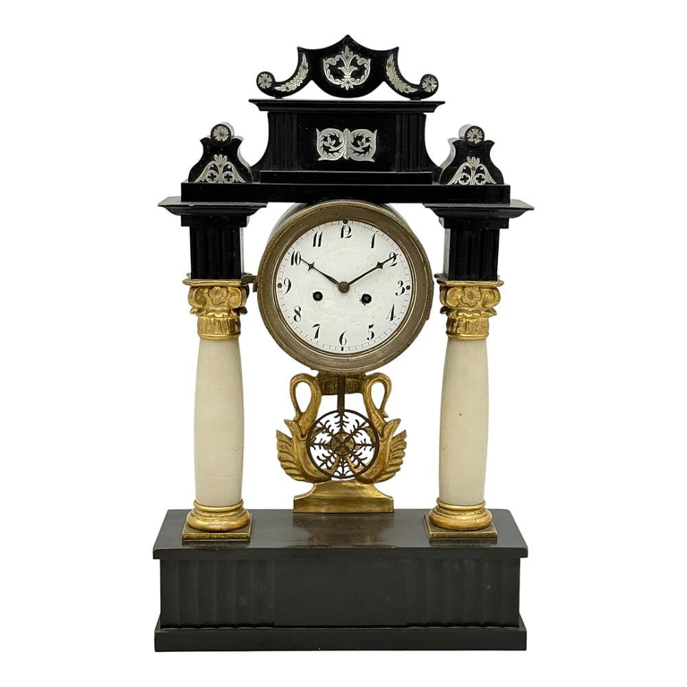 Frontal view of the ebonised wood portal clock with white columns, dial, and swan ornament