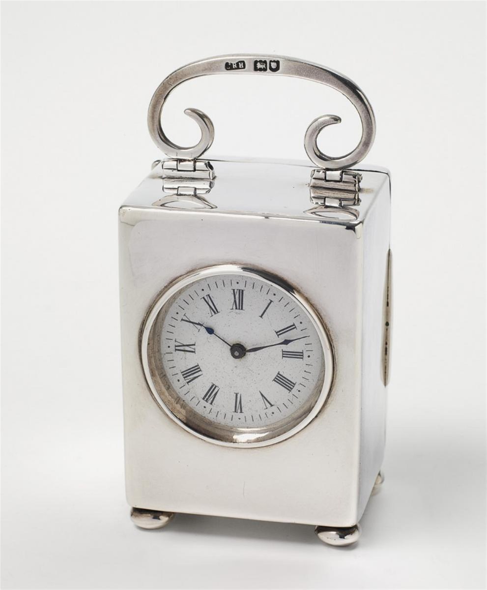Front three-quarter view of the Edward VII silver travel clock showing handle, hallmarks, and dial