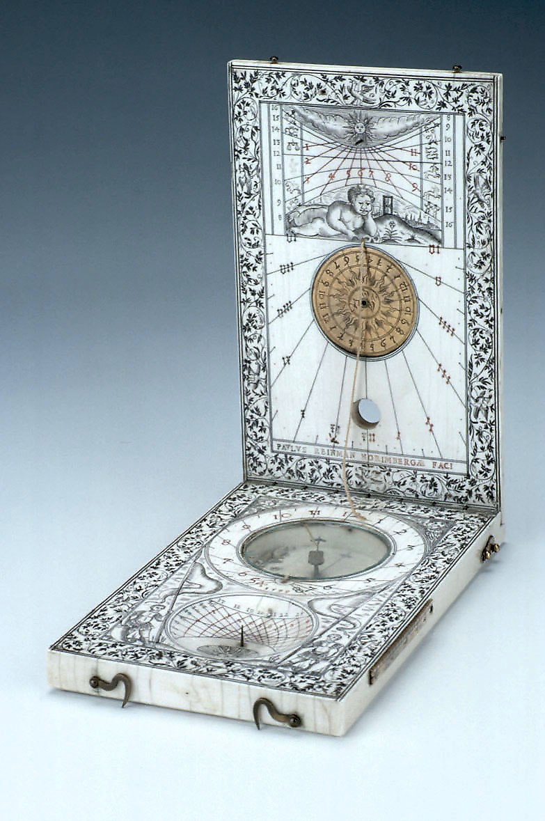 The open diptych dial, showing the ivory construction, internal brass dials, and intricate engraved iconography.