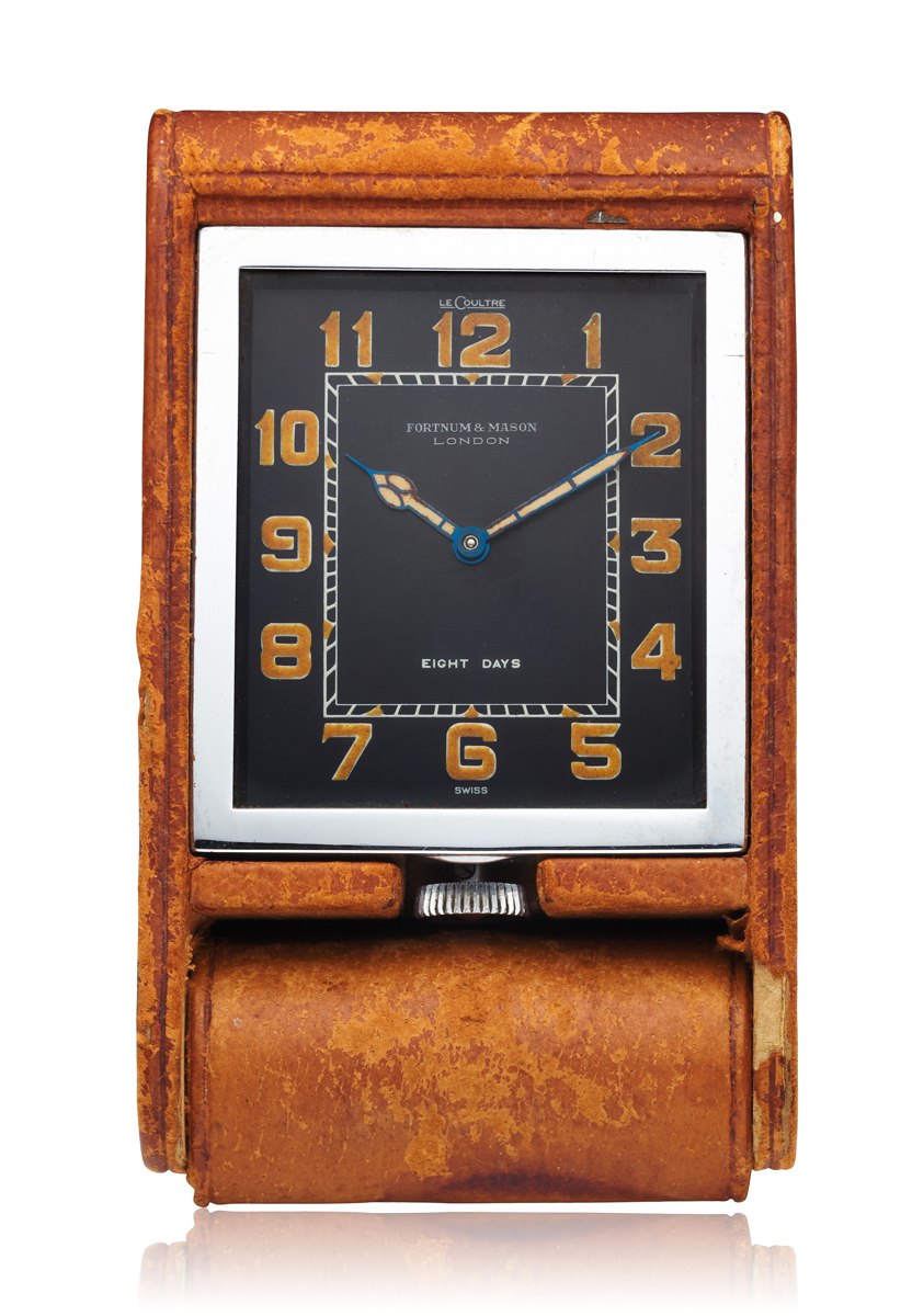 Front view of the LeCoultre 8-day travel clock mounted in its open tan leather case