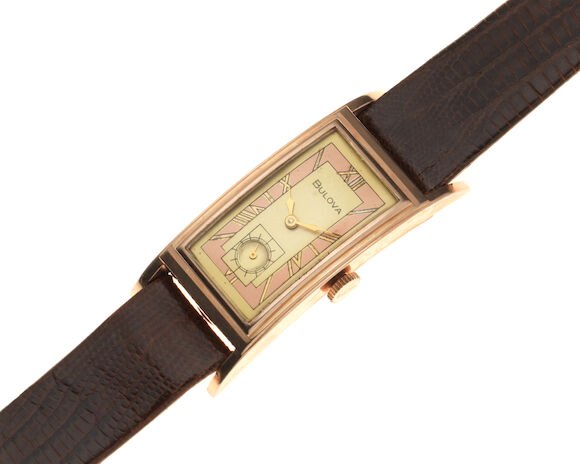 Oblique view of the Bulova rose gold-plated rectangular curved wristwatch on a brown leather strap