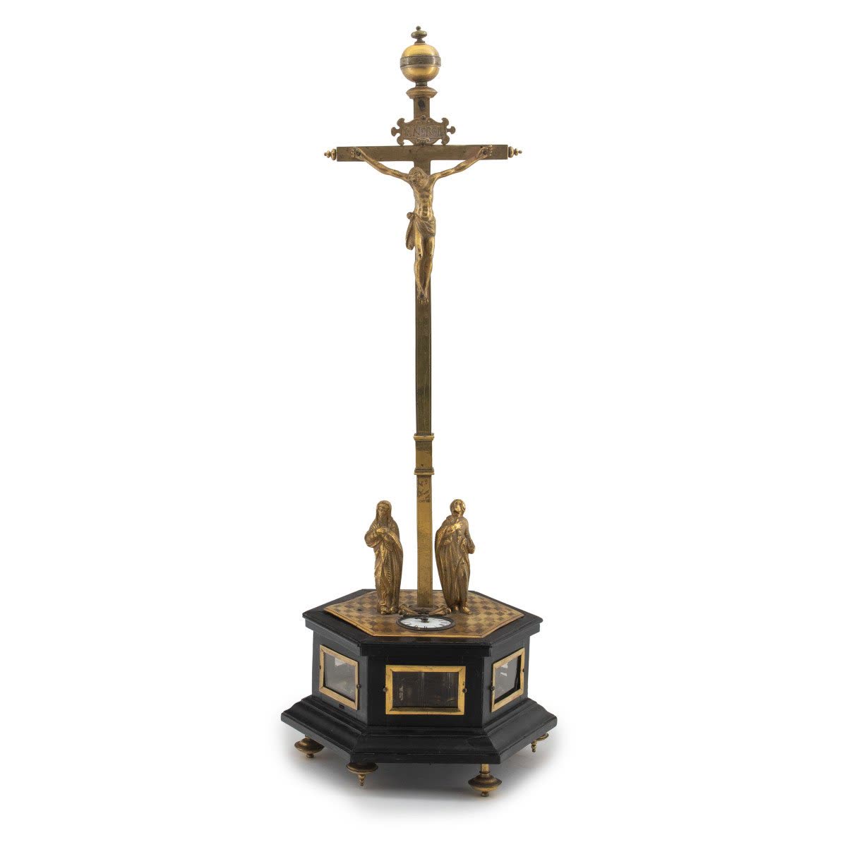 Front view of the crucifix table clock showing the gilt bronze figures, cross, and ebonized hexagonal base