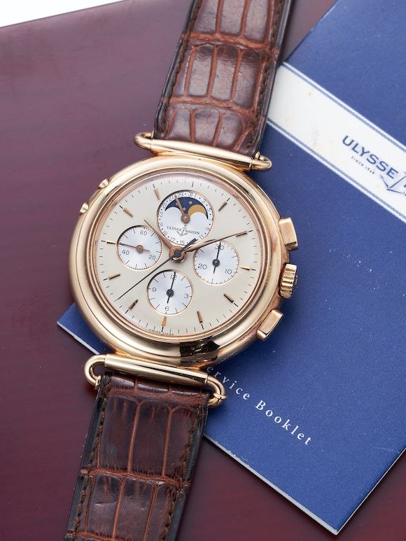 Ulysse Nardin Ref. 541-22 pink gold chronograph wristwatch shown resting on its service booklet