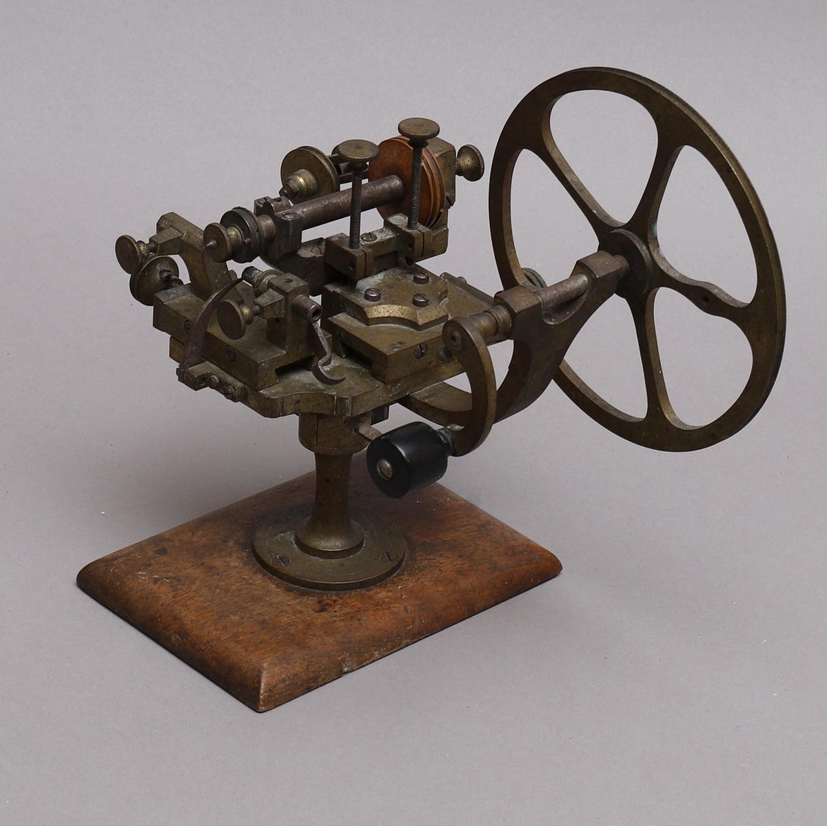 Hand-operated watchmaker's lathe mounted on a wooden base