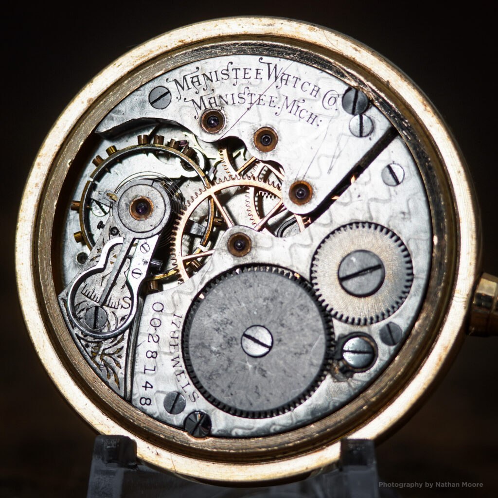 Movement view of Manistee Watch Co. 16-size movement serial number 0028148, showing plate layout, micrometric regulator, and bridge engravings.