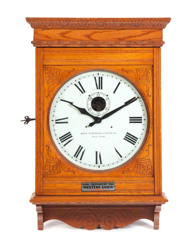 Front view of Self Winding Clock Company oak wall clock with Western Union plaque