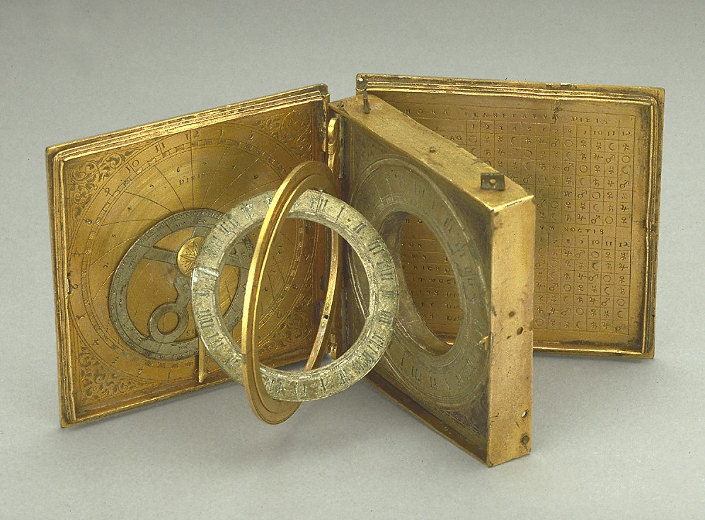 An overview of the open astronomical compendium, showing the interior leaves, the universal equinoctial dial, and the planetary table.