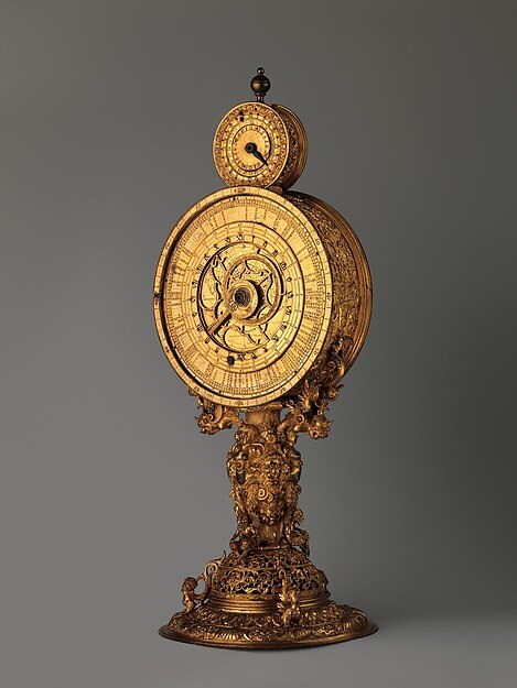 Front view of the mirror clock showing the dial with the astrolabe rete and calendar ring.
