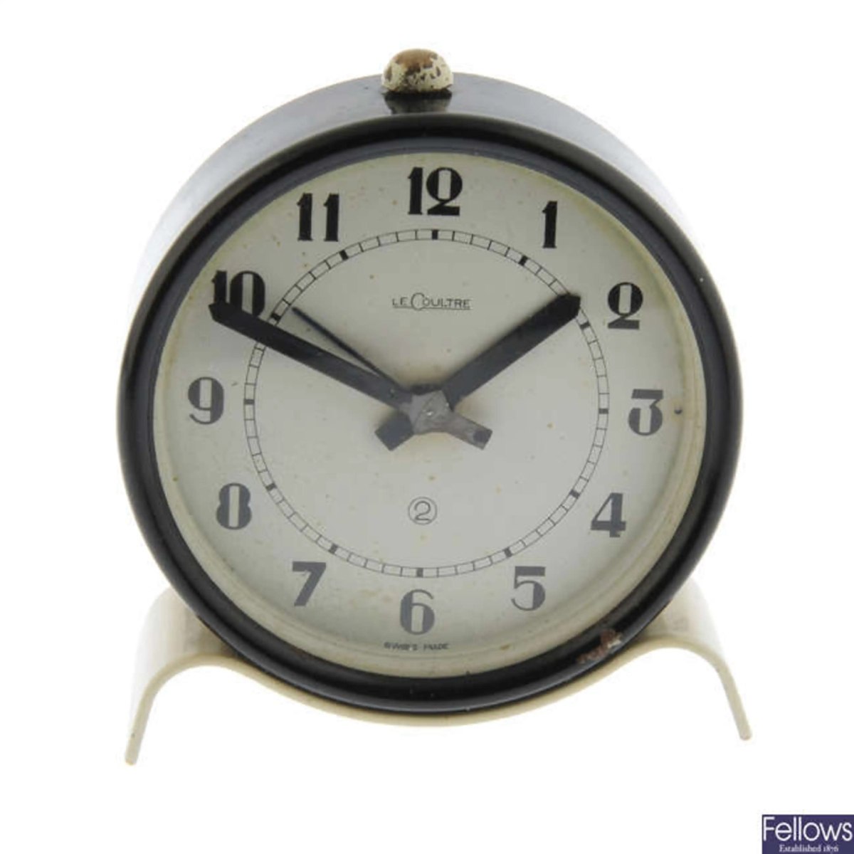 Front view of the LeCoultre alarm clock showing cream dial and base metal case