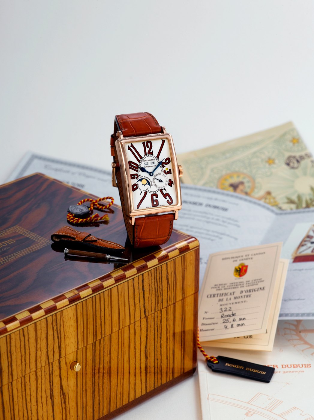 The Roger Dubuis Much-More wristwatch accompanied by its box, COSC certificate, and manual.