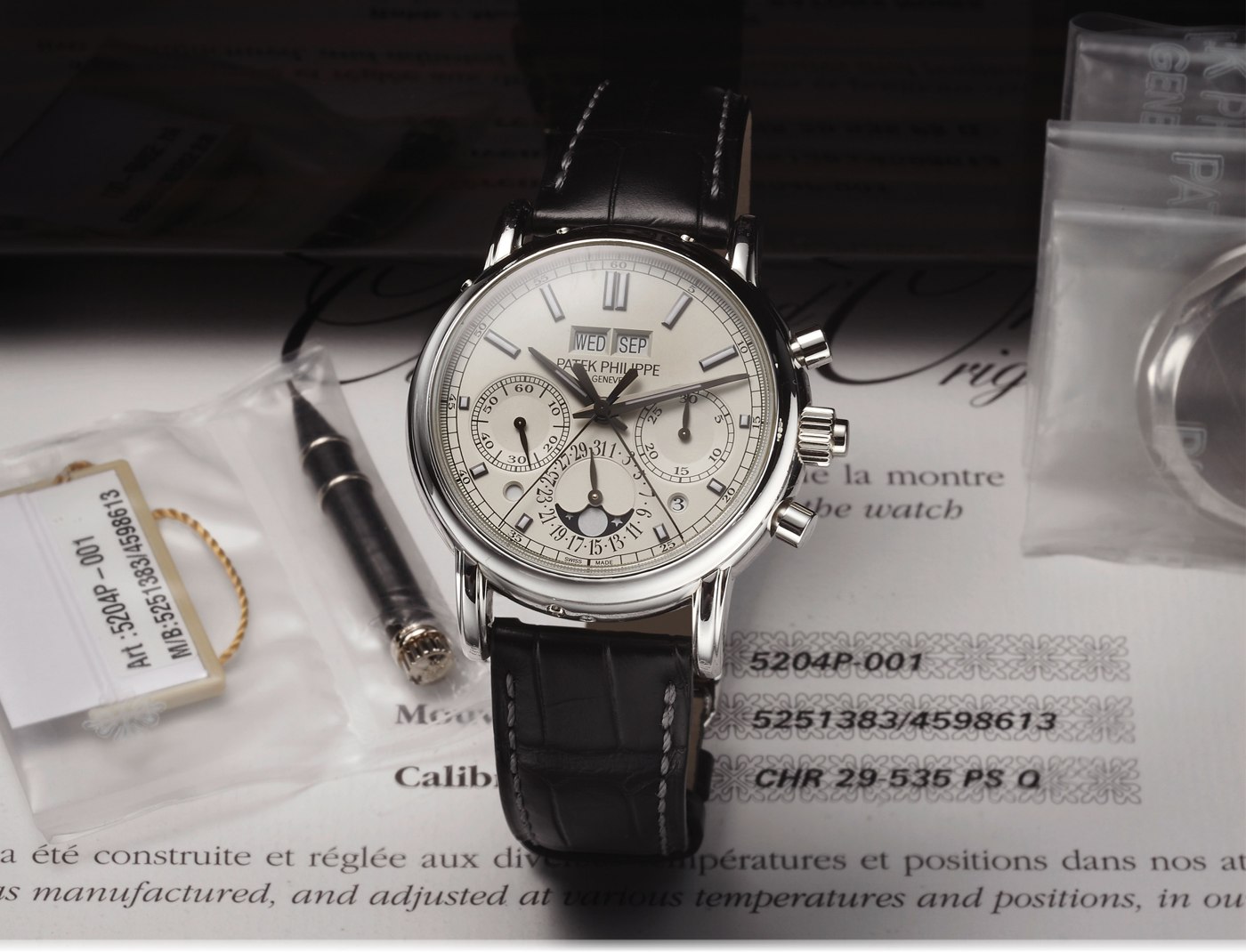 Patek Philippe Ref. 5204P-001 timepiece, shown with its accompanying setting pin and documentation.