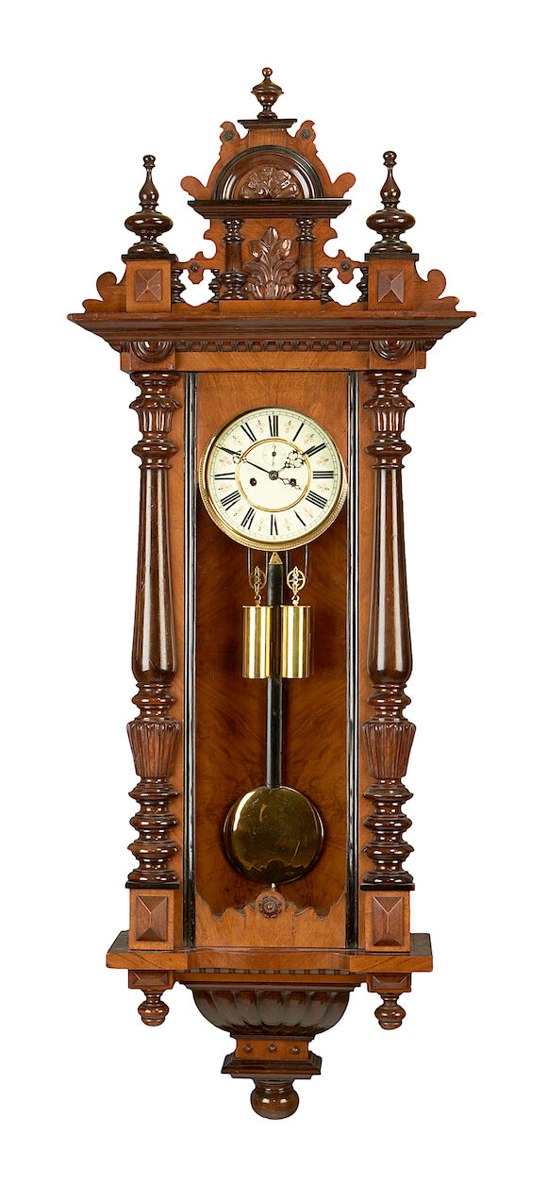 Front view of the walnut Vienna-style regulator clock with weights and pendulum visible