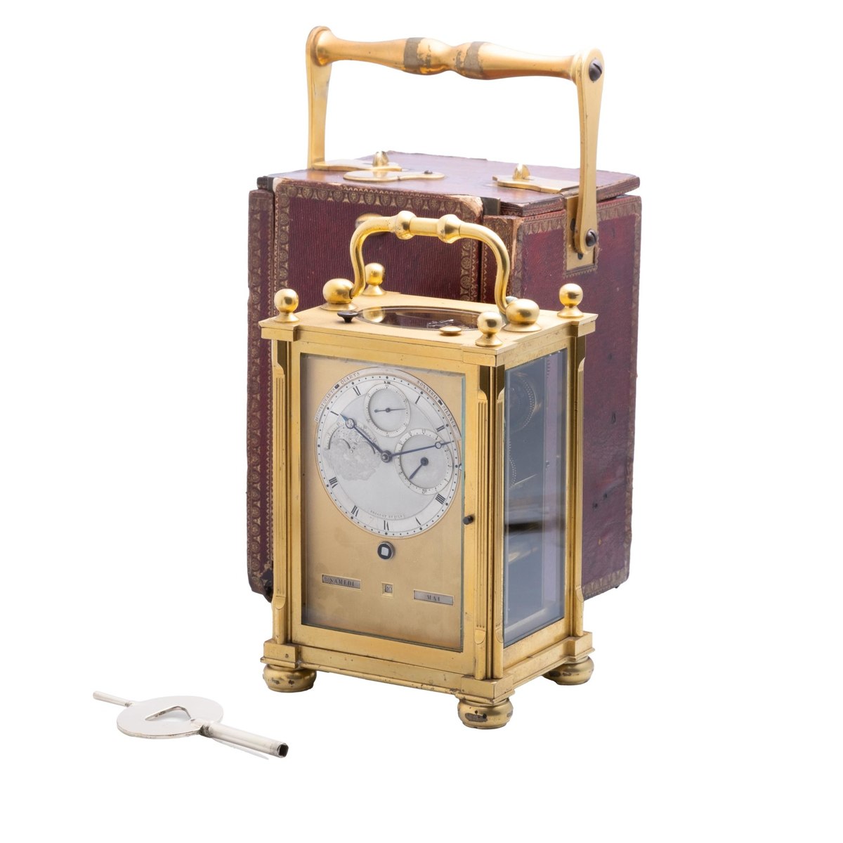 Three-quarter front view of the Breguet & Fils gilt bronze carriage clock with winding key and red morocco travelling box