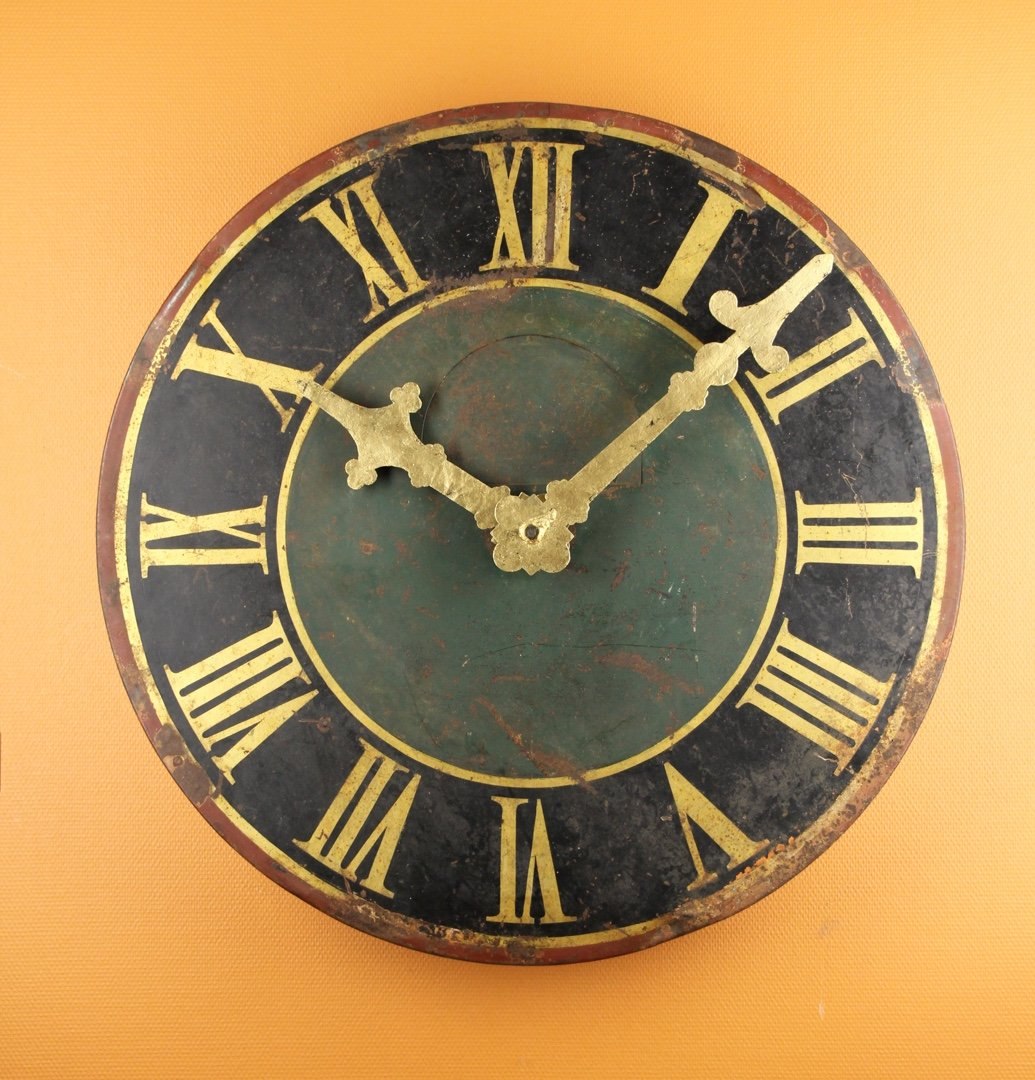 Front view of the painted tower clock dial with ornamental gilt hands