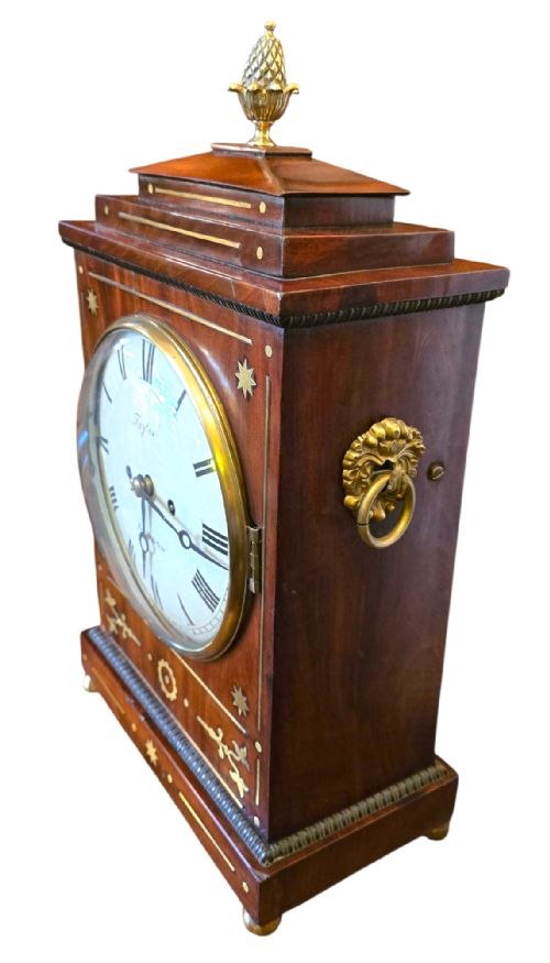 Three-quarter perspective view of the mahogany chamfer top bracket clock showing dial, brass inlays, and side ring handle