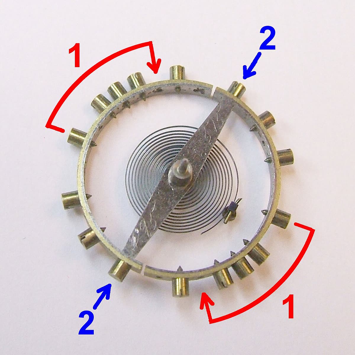A detached pocket-watch balance assembly with its spring visible. Different balances use different rim, screw and spring arrangements.