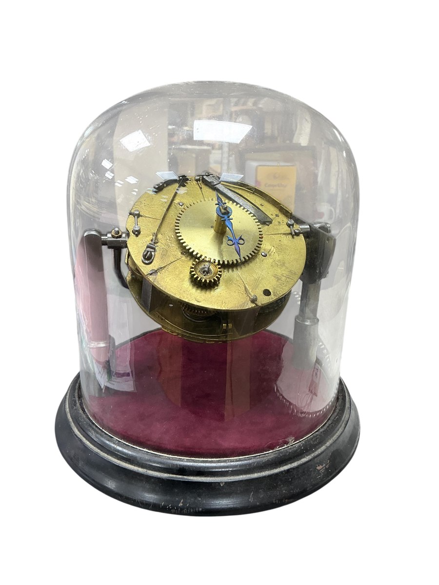 Table clock movement under a glass dome on a wooden base