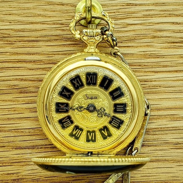 Dial and open front cover of the Sheffield pocket watch showing the ornate bow and chain