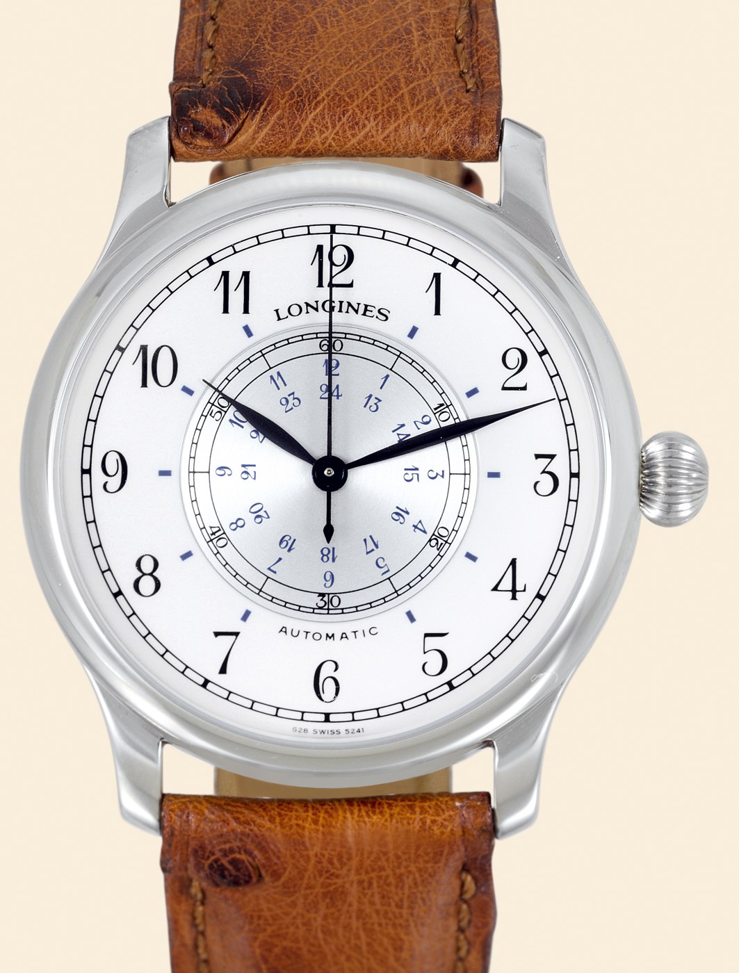 Close-up view of the white enamel dial showing Arabic numerals, central revolving time-zone disc, and blued steel hands.
