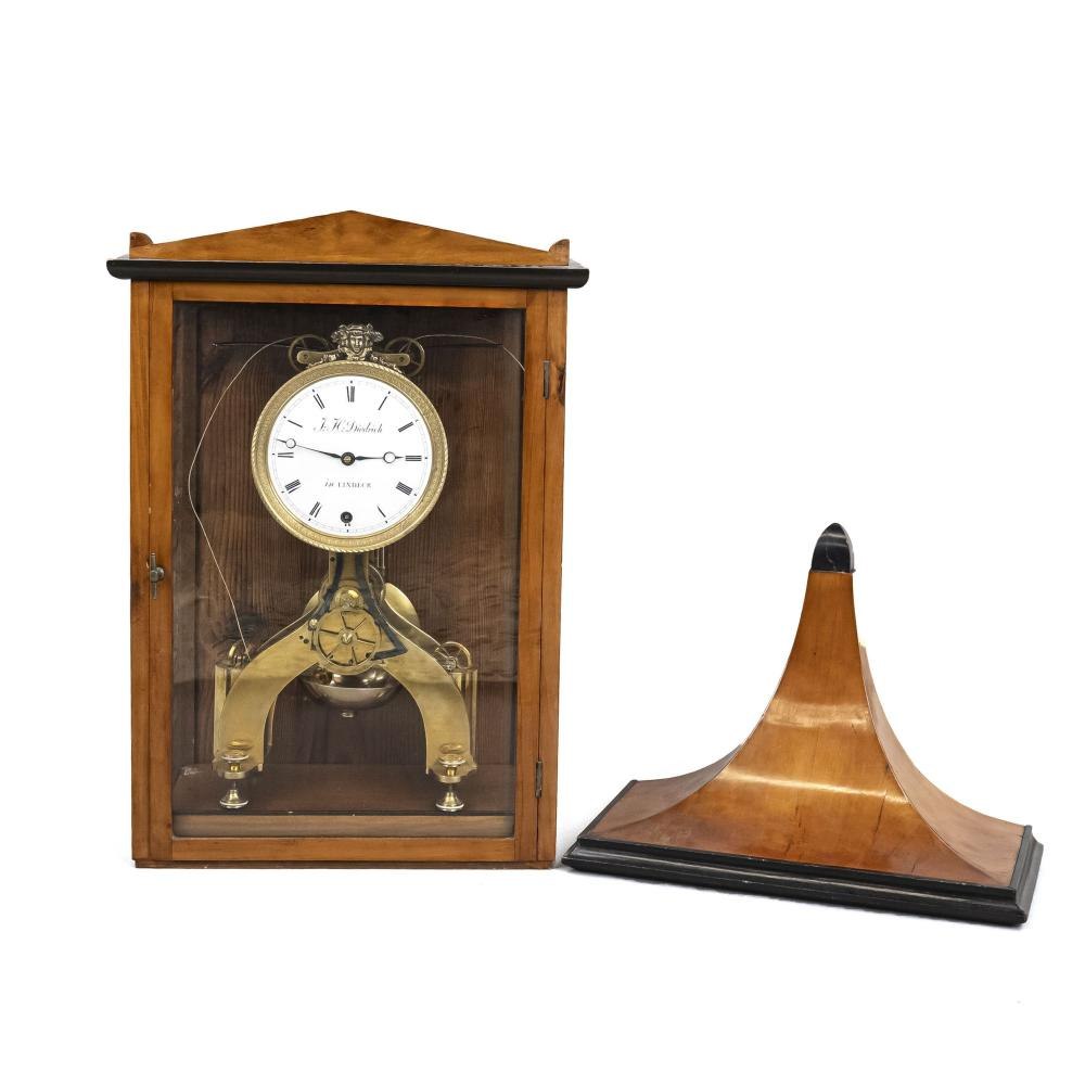 Front view of the J.K. Diedrich skeleton clock inside its wooden case shown alongside its console