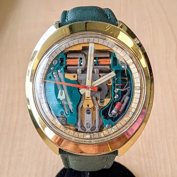 Front view of the Bulova Accutron Spaceview showing the exposed movement, chapter ring, and green leather strap