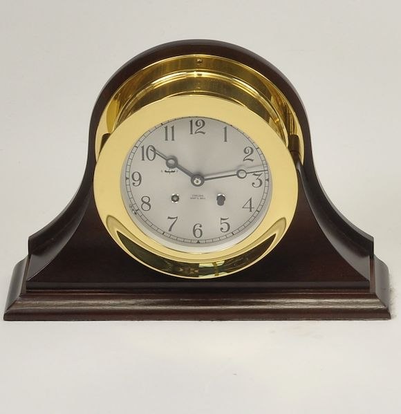 Chelsea Ship's Bell brass clock set within a modern mahogany mantel mount