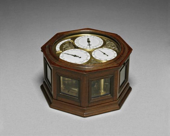 High-angle view of Thomas Mudge's Marine Timekeeper No. 1 in its glazed octagonal mahogany case showing dial layout and movement side apertures