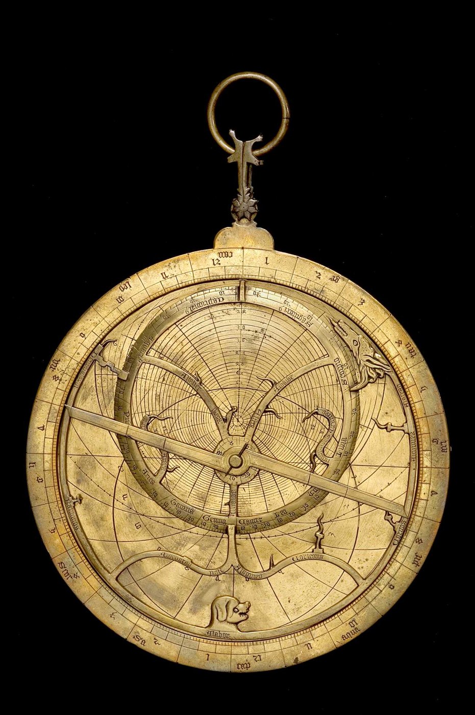 Front view of the brass astrolabe showing the Y-shaped rete and zoomorphic star pointers.