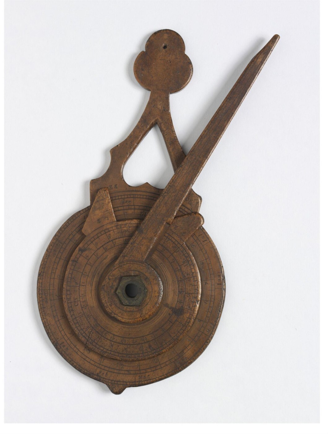 Front view of the engraved applewood nocturnal showing the pointer and central aperture.