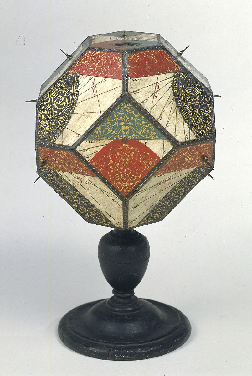Polyhedral sundial in wood with gold foliate decoration and black-on-white dial markings, supported by a baluster stand.