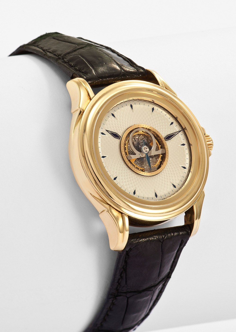 The watch front, displaying the central flying tourbillon, guilloché dial, and the 18K yellow gold case.