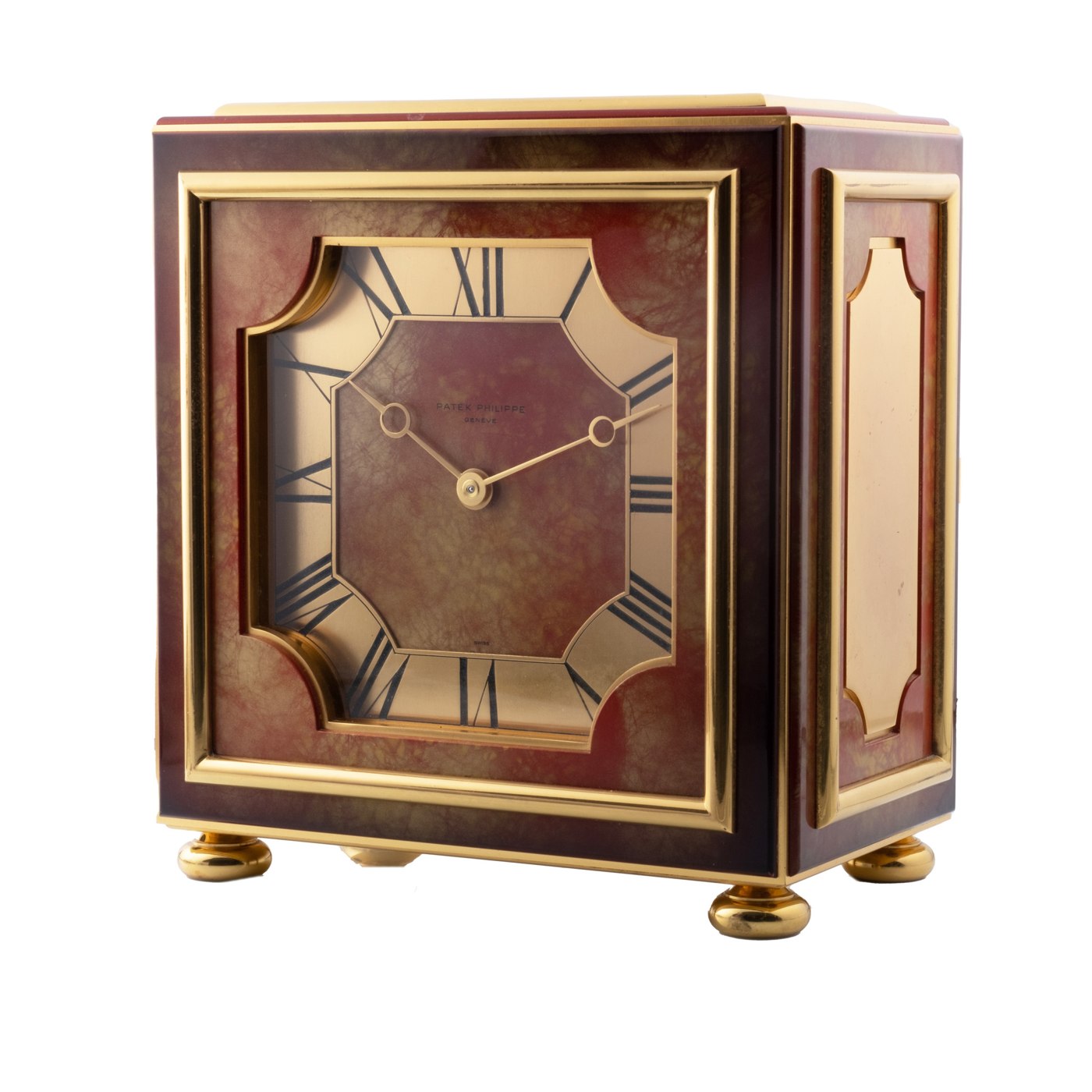 A side-profile view of the Patek Philippe table clock showing the marble-effect lacquered panels and the octagonal dial.