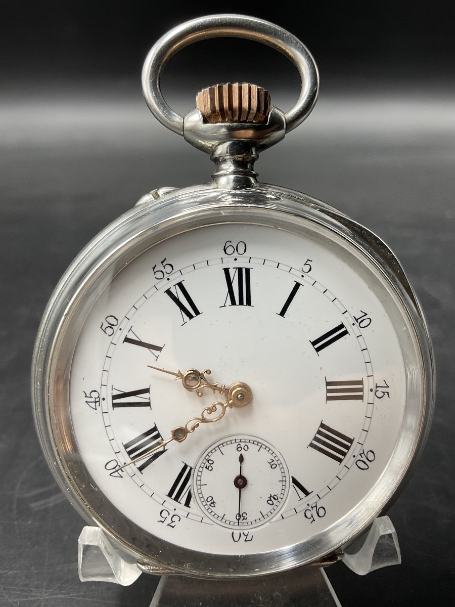 Front view of the silver pocket watch displaying the white enamel dial on a stand