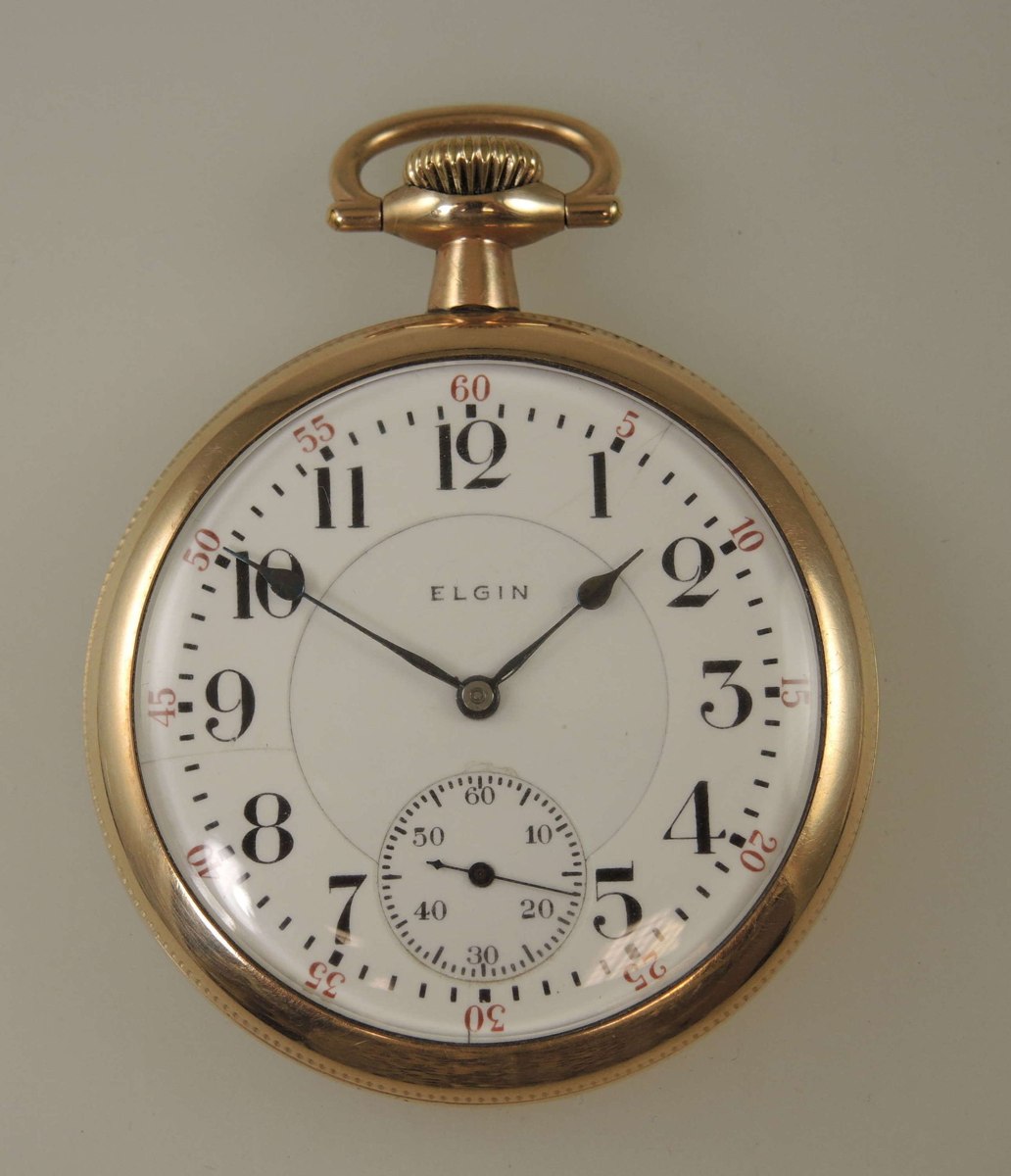 Front view of the Elgin B.W. Raymond pocket watch showing the enamel dial and gold-plated case
