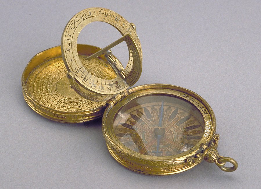 Gilt brass astronomical compendium by Humfrey Cole, 1575, showing the opened dial, compass, and internal inscriptions.