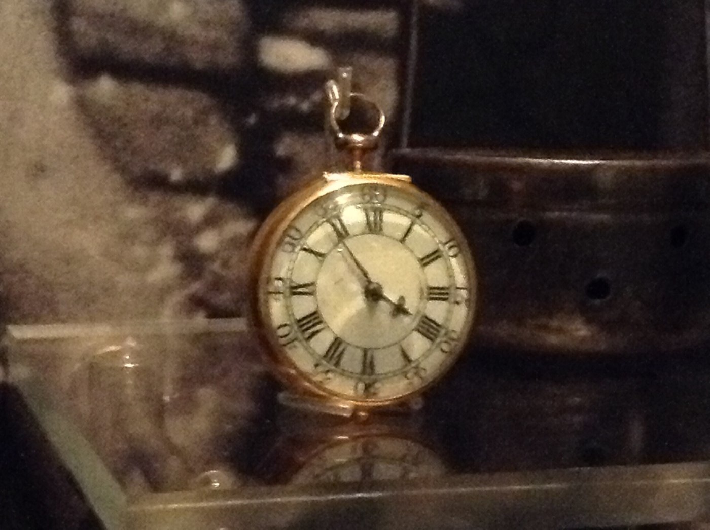 The white enamel dial of the George Graham pocket watch, showing the Roman hour numerals and the outer Arabic minute ring.