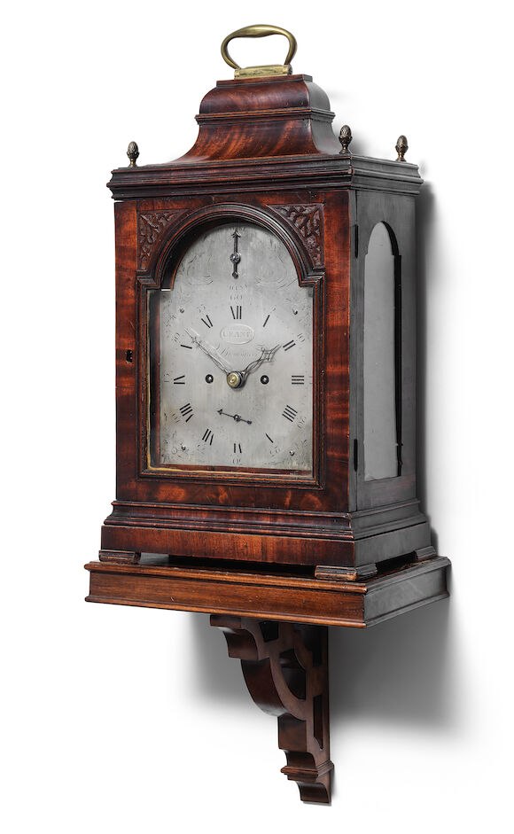Three-quarter perspective of the 18th-century mahogany bracket clock on its pierced bracket, signed Crane, Bromsgrove